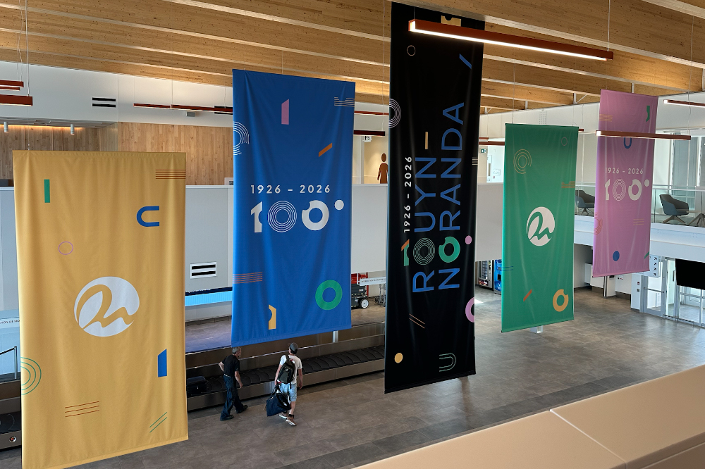 Bannières suspendues au plafond de l'aéroport régional de Rouyn-Noranda pour souligner le 100e de la ville