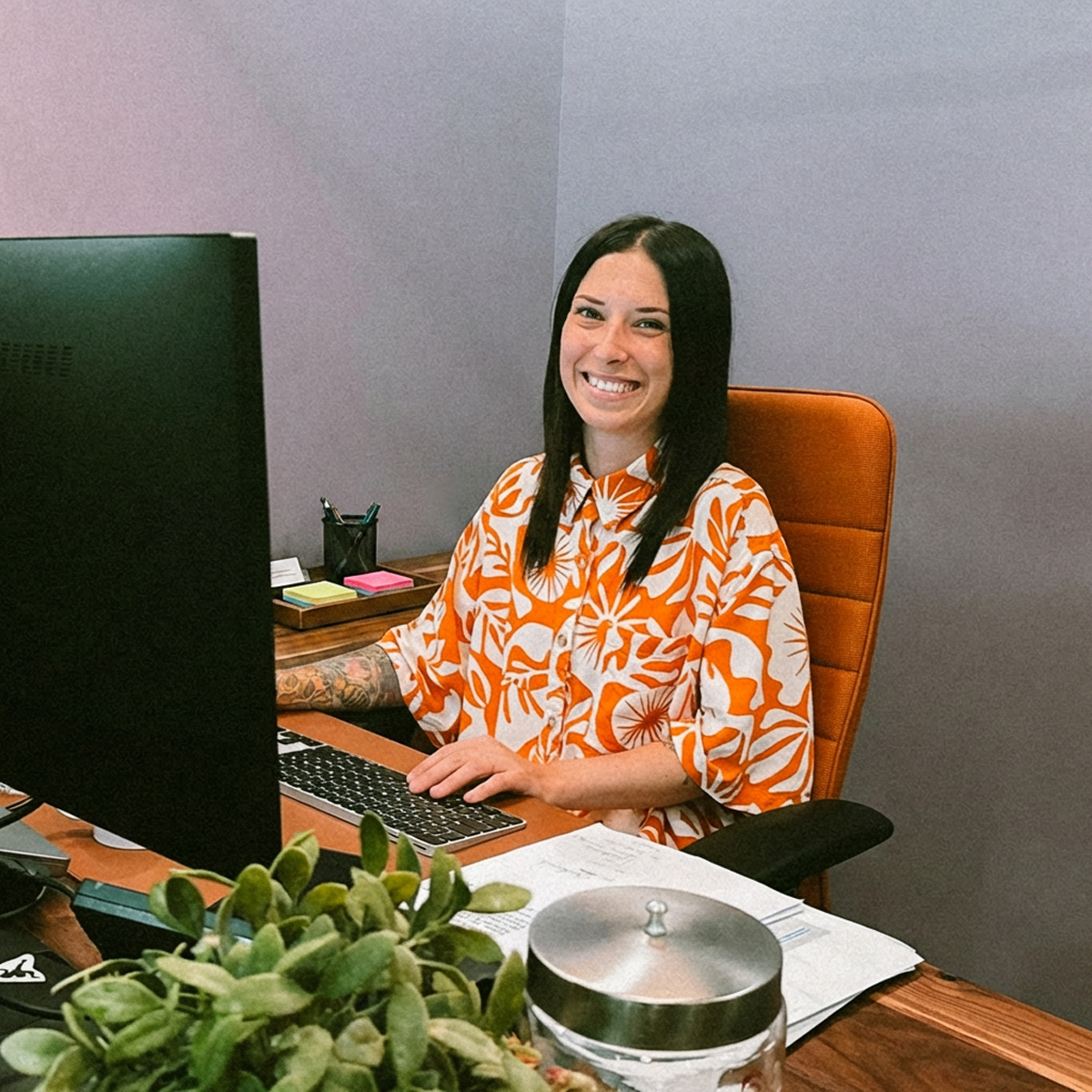 Marie-Ève assise à son bureau, sourit à la caméra